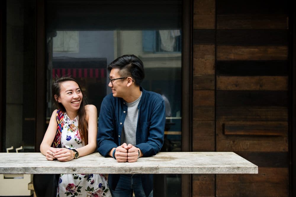 A couple standing at a table looking at each other with smiles on their faces. Infatuation vs Love - 1.jpg