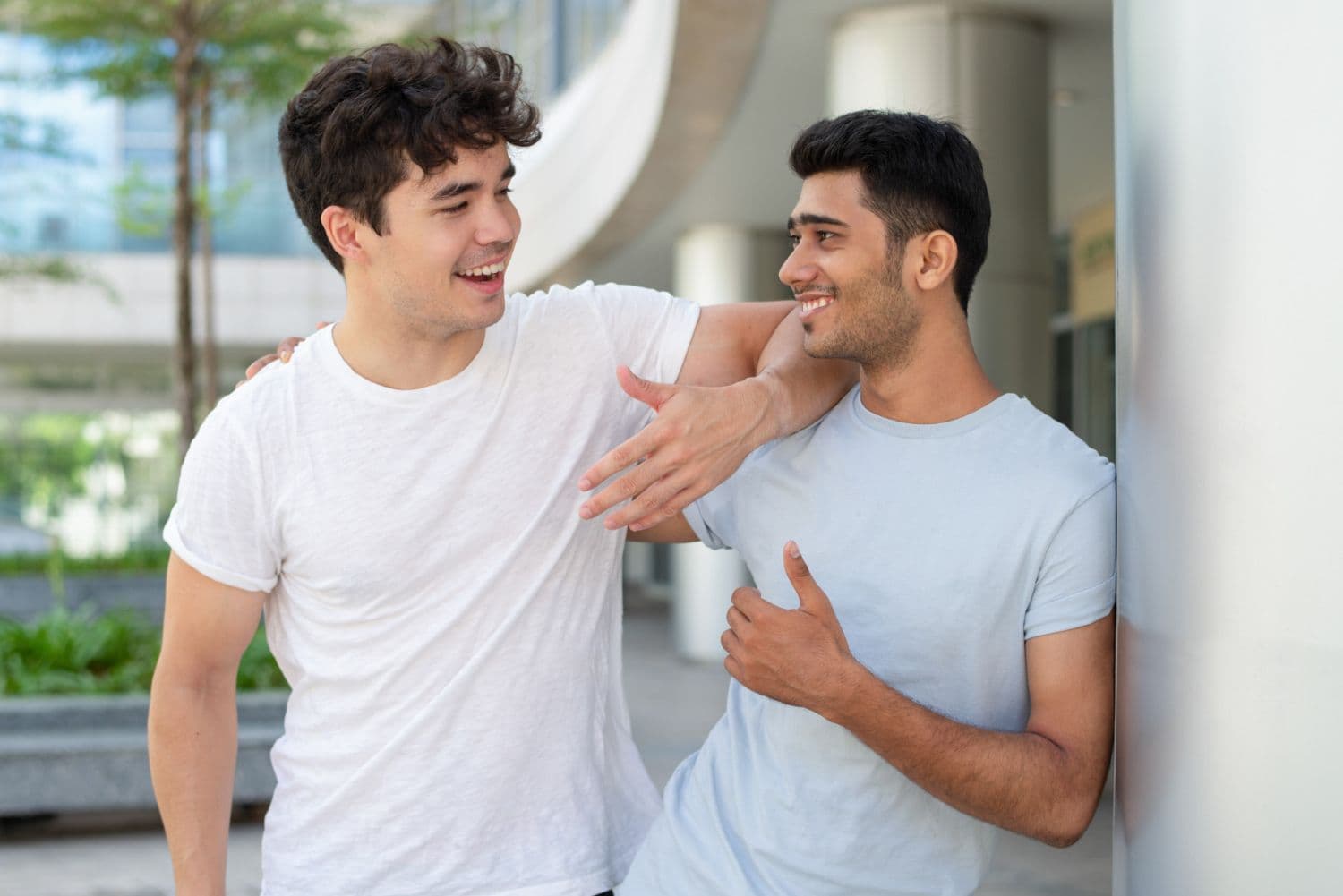 A gay couple smiling and talking to each other with their arms around each other. Infatuation vs Love - 2