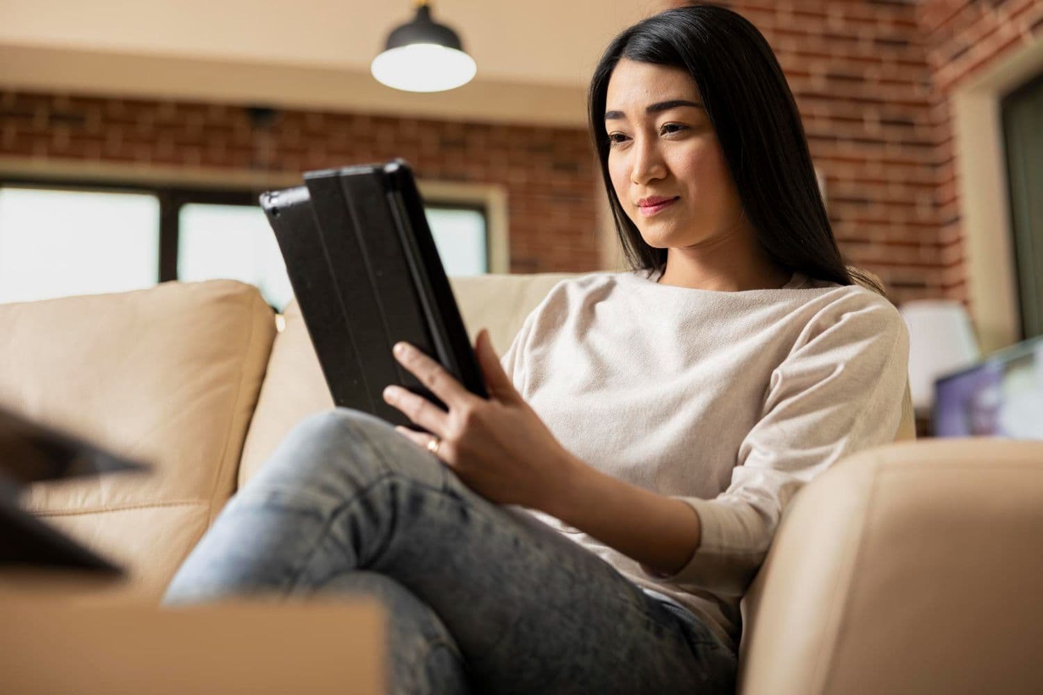 A Singaporean woman reading happiness quotes on a tablet.