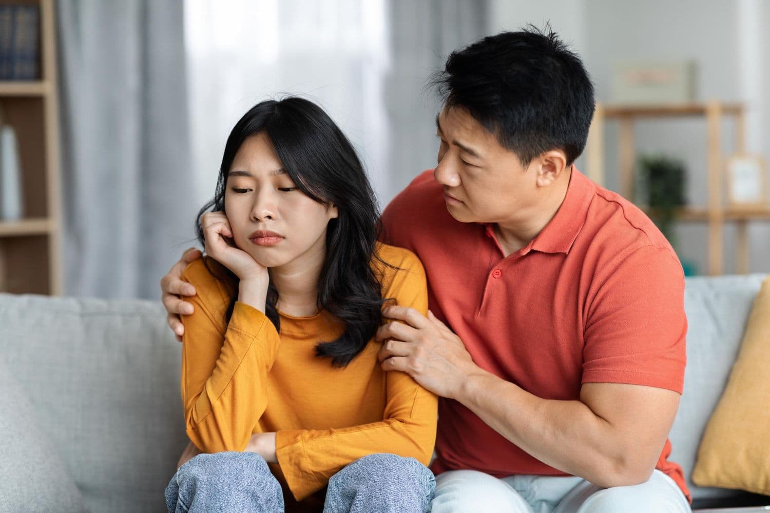 A couple sitting beside each other and looking upset, hoping to receive couples therapy in Singapore.