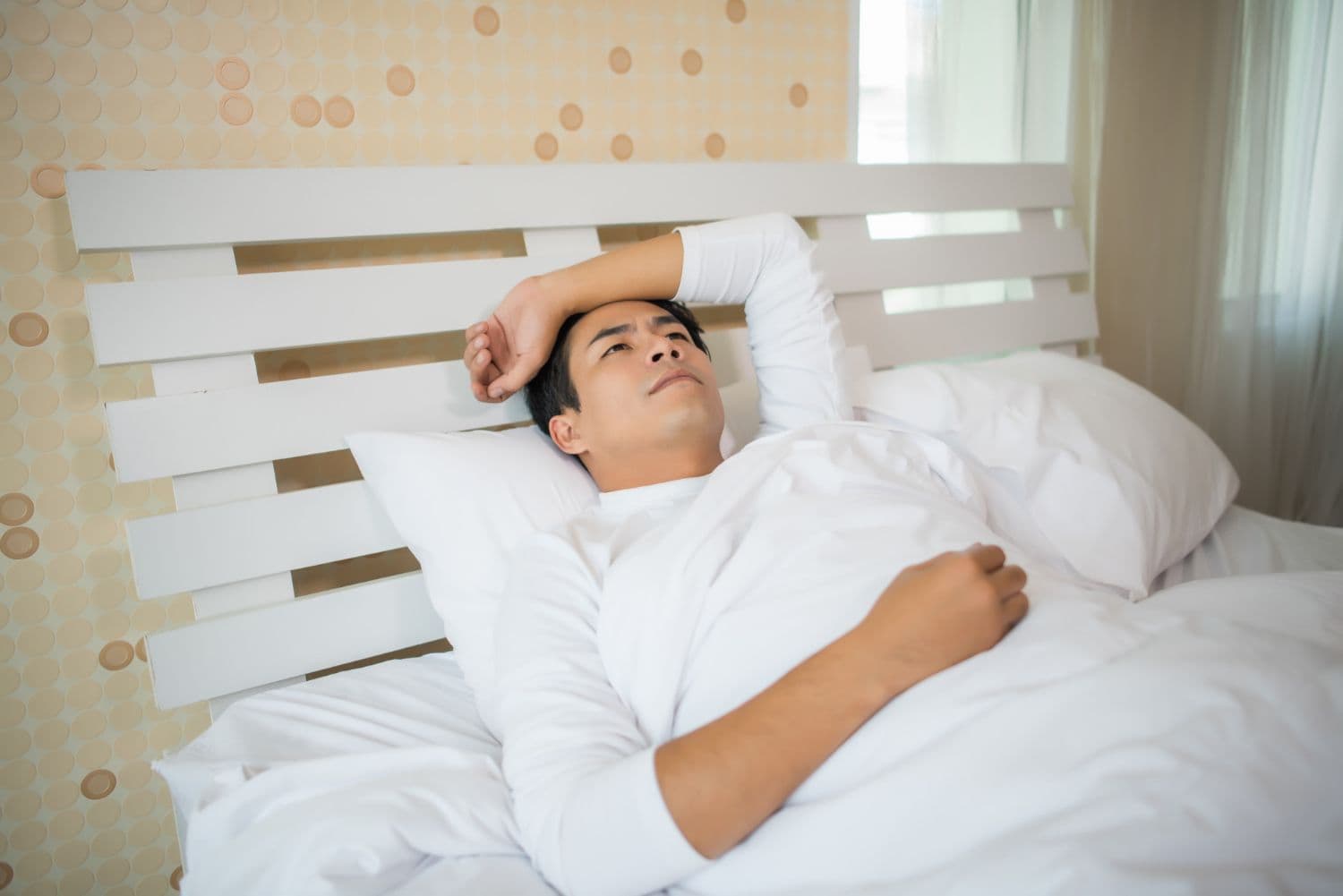 A person lying awake in bed due to onset insomnia.